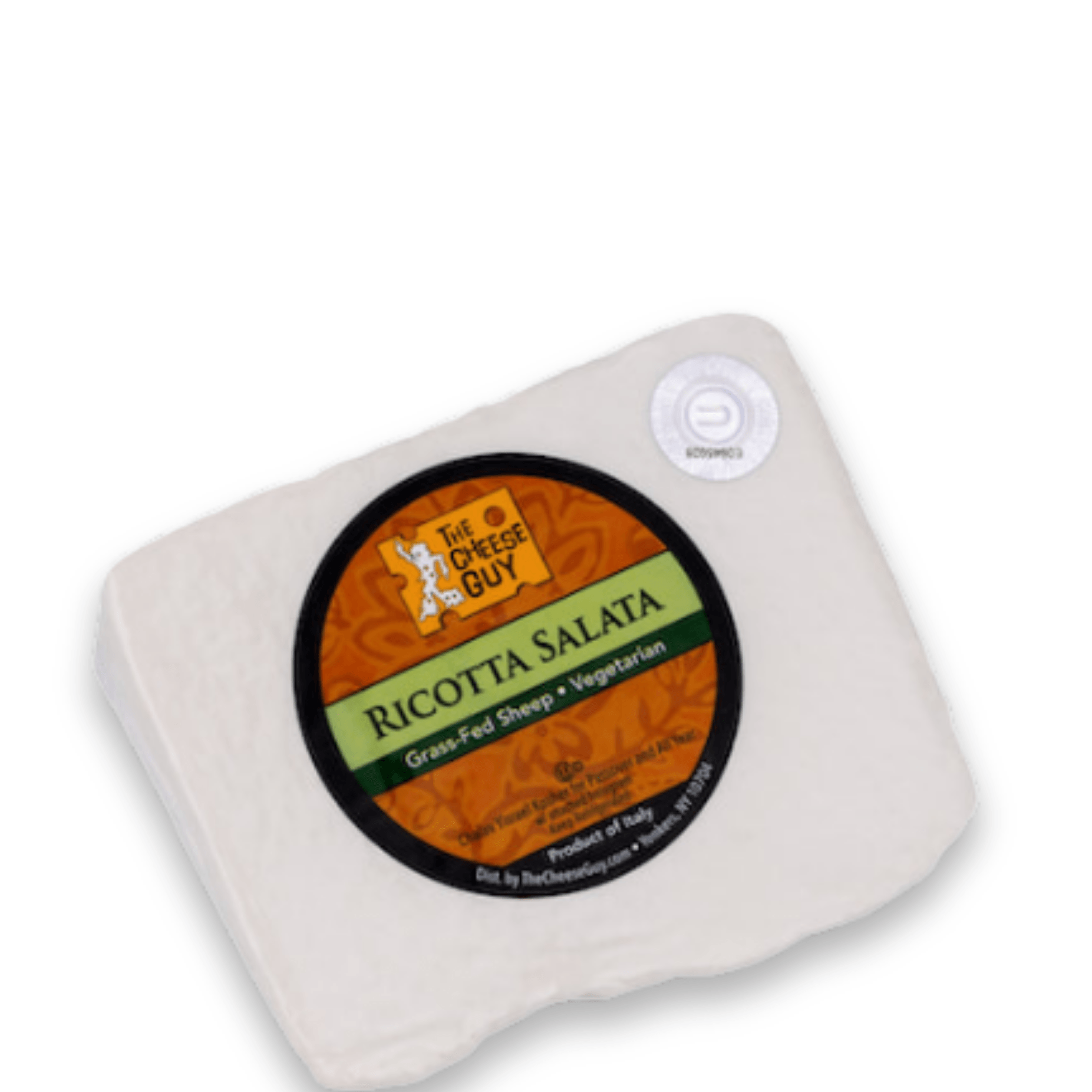 A wedge of The Cheese Guy Ricotta Salata cheese features a circular black and orange label with the product name in bold green letters, indicating it's made from grass-fed sheep and is vegetarian.