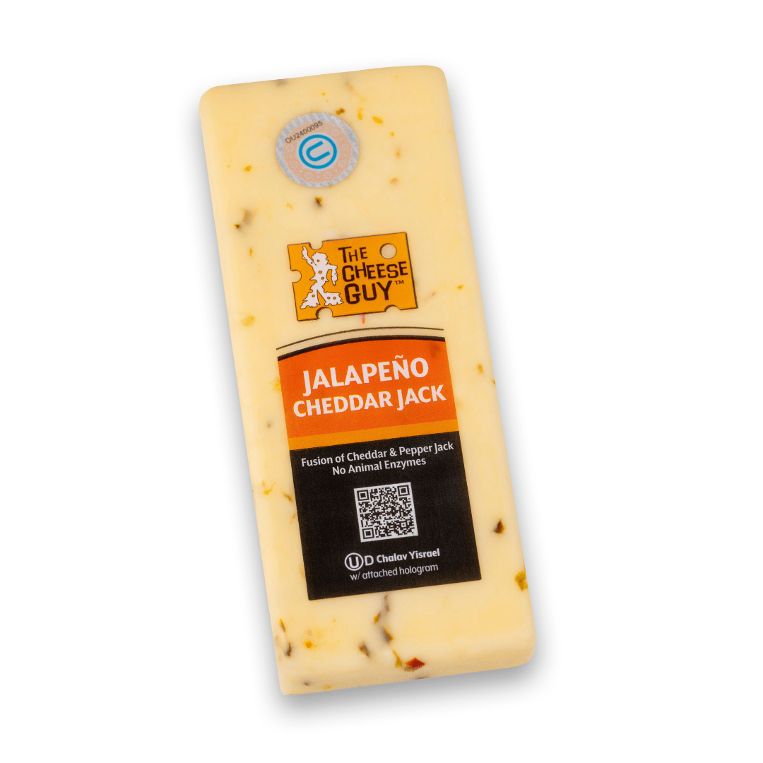 Image of The Cheese Guy Jalapeno Cheddar Jack, a light-colored rectangular block of cheese with jalapeno pieces, showing the brand logo and 'Jalapeno Cheddar Jack' product name on the label, highlighting 'Fusion of Cheddar & Pepper Jack' and 'No Animal Enzymes'.