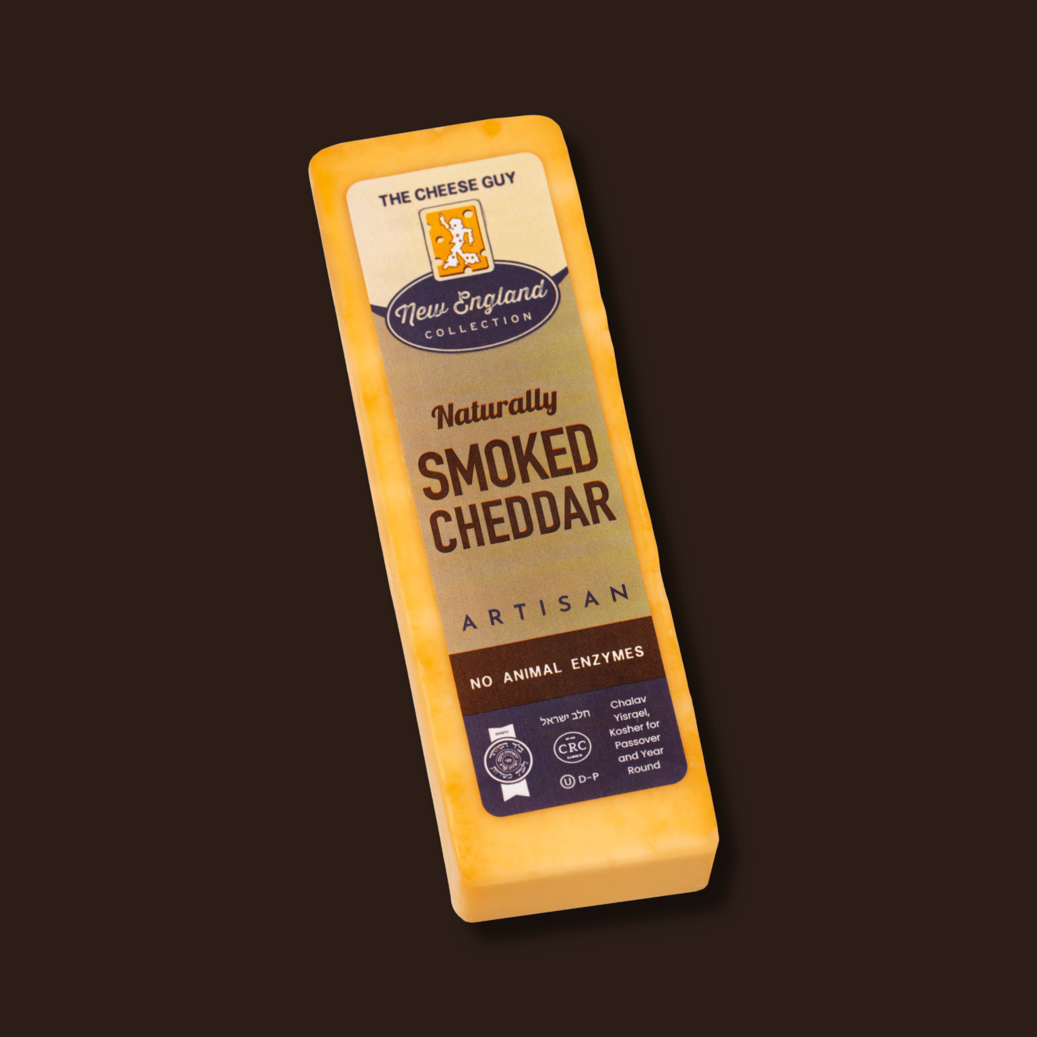 A block of The Cheese Guy Naturally Smoked Cheddar Artisan cheese. The label highlights "NO ANIMAL ENZYMES" and "CRC Kosher for Passover and Year Round," indicating it's a kosher smoked cheese product in a yellow label and dark brown background.
